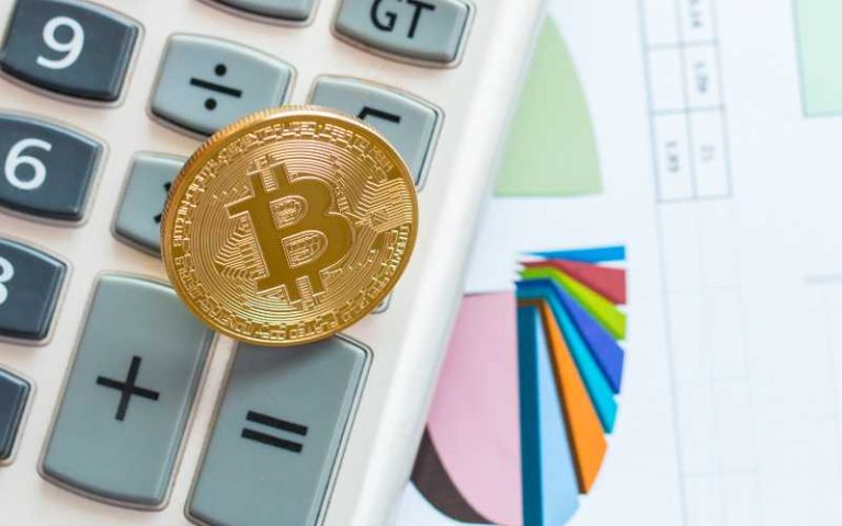 Moneda Bitcoin sobre calculadora